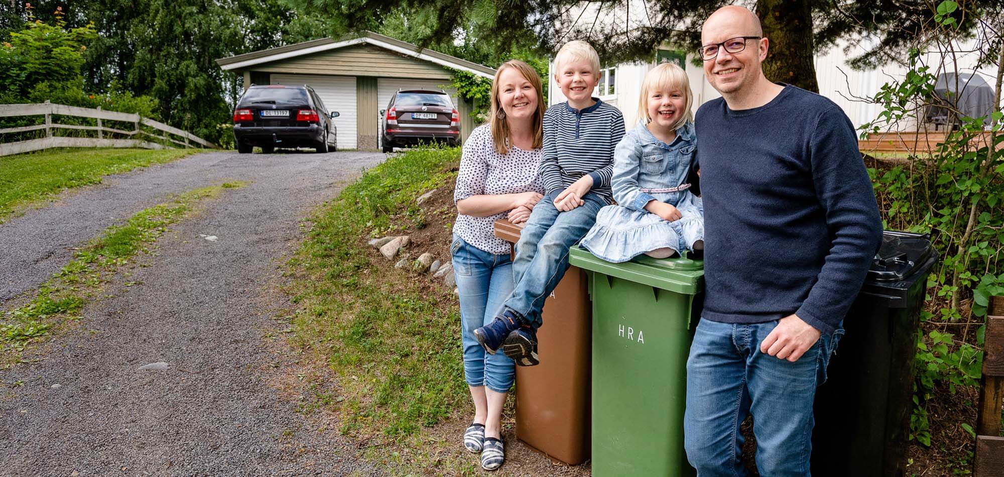 Familie på fire foran avfallsdunker fra HRA