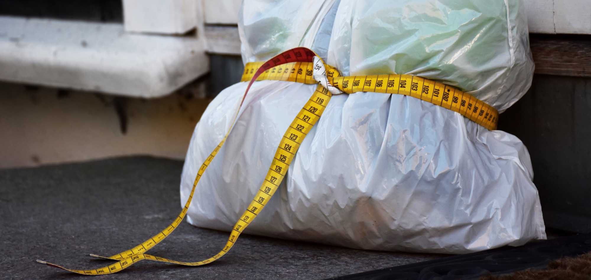 Avfallspose med målebånd rundt - slik slanker du restavfallet ditt.