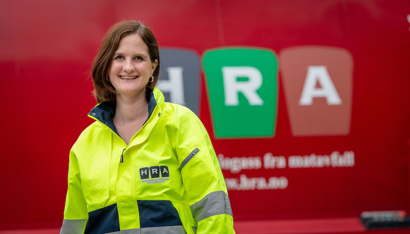 Kommunikasjonssjef Åse Toril Krågsrud foran rød renovasjonsbil fra HRA.